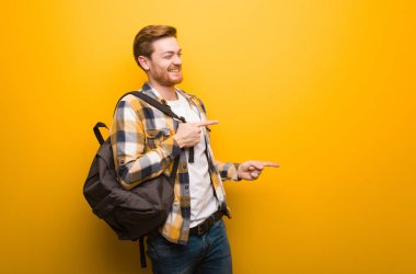 Genç kızıl saçlı öğrenci parmağıyla kenarı işaret ediyor.