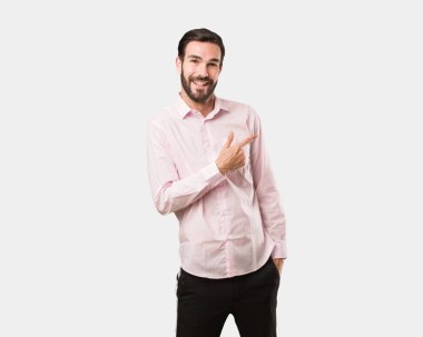 Gülümseyen ve tarafına işaret eden genç yakışıklı adam