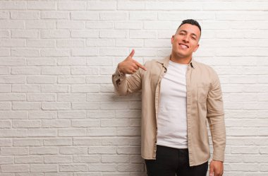 Genç Latin bir adam gömleği elle gösteriyor. Fotokopi odası, gururlu ve kendinden emin.