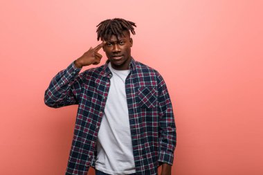 Genç Afrikalı siyah adam işaret parmağıyla hayal kırıklığı jesti yapıyor..