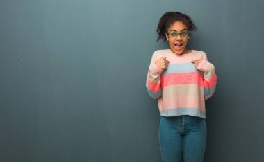 Sürpriz, mavi gözlü genç Afro-Amerikan kız başarılı ve müreffeh hissediyorum