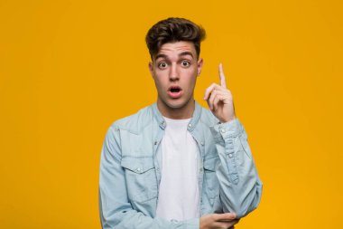 Kot gömlek giyen genç yakışıklı bir öğrencinin harika bir fikri var, yaratıcılık kavramı..