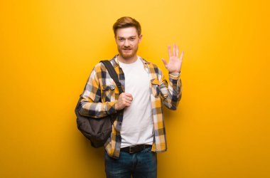 Kızıl saçlı genç adam 5 numarayı gösteriyor.