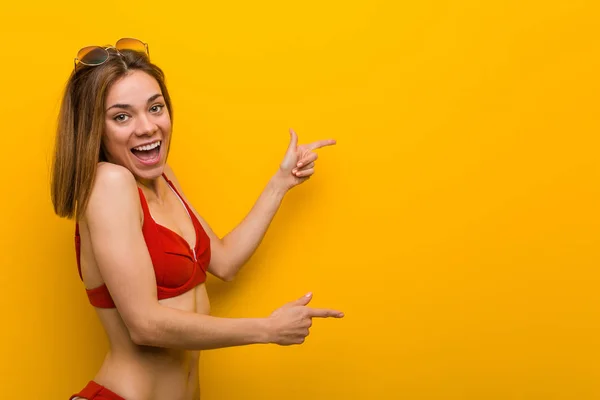 Young Caucasian Woman Wearing Bikini Sunglasses Excited Pointing Forefingers Away — Stok fotoğraf