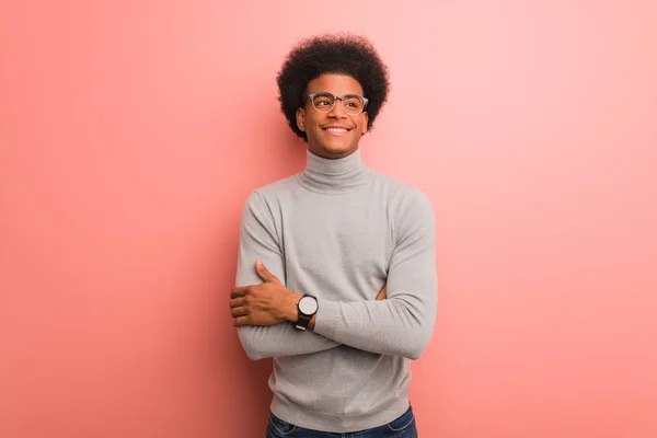 Jovem Afro Americano Sobre Uma Parede Rosa Sorrindo Confiante Cruzando — Fotografia de Stock