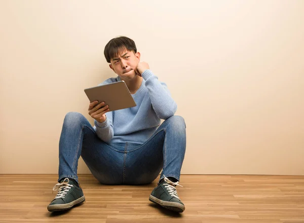Joven Hombre Chino Sentado Usando Tableta Pensando Una Idea — Foto de Stock