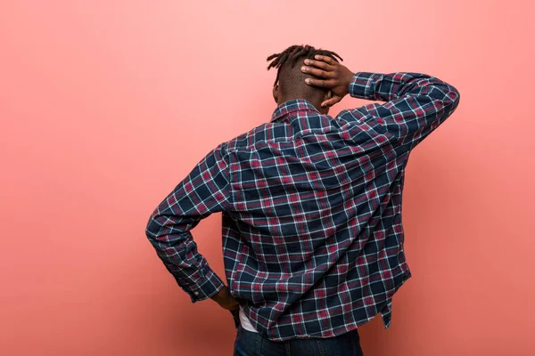 Young african black man from behind thinking about something.