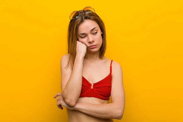 Young caucasian woman wearing bikini and sunglasses who feels sad and  pensive, looking at copy space. - Stock Image - Everypixel
