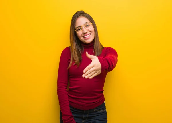 Young intellectual woman reaching out to greet someone