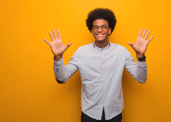 Молодий Афроамериканець Над Оранжевою Стіною Номером Десять — стокове фото