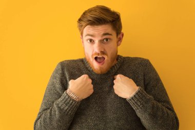 Genç kızıl saçlı adam şaşırmış, başarılı ve başarılı hissediyor.