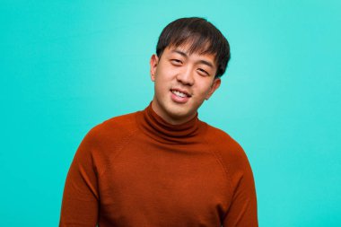 Genç Çinli adam büyük bir gülümseme ile neşeli