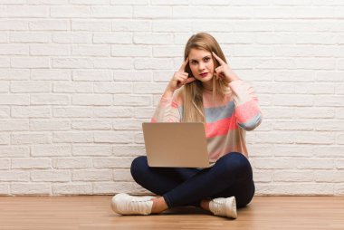 Genç Rus öğrenci kadın, oturmuş konsantrasyon jesti yapıyor.