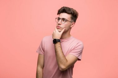 Şüpheli ve şüpheci bir ifadeyle yan bakan genç, havalı, beyaz bir adam..