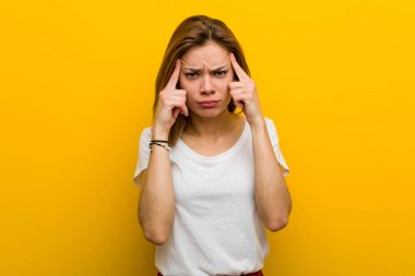 Young natural caucasian woman focused on a task, keeping her forefingers pointing head.