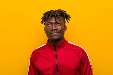 Genç fitness Afrikalı adamın kafası karışık, kuşkulu ve kararsız..