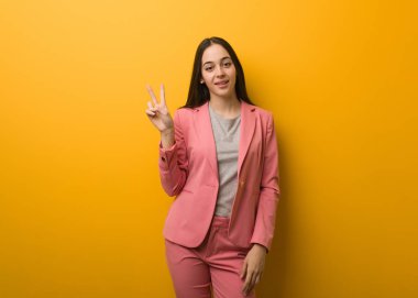 Genç, modern iş kadını zafer jesti yapıyor.