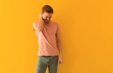 Kızıl saçlı genç adam boyun ağrısı çekiyor.