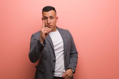 Genç, zarif Latin adam bir numarayı gösteriyor.