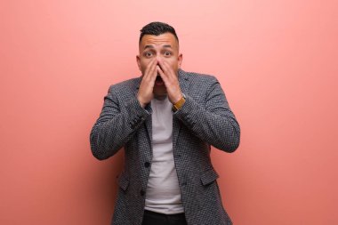 Young elegant latin man very scared and afraid hidden