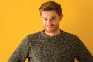 Genç kızıl saçlı adam yüzü, elleri kalçasında yakın çekim.