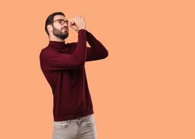 Genç, doğal bir adam dürbün hareketi yapıyor.