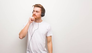 Genç kızıl saçlı şüpheli ve kafası karışık bir adam. Kulaklıkla müzik dinlemek..