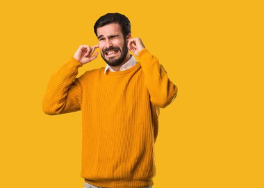 Genç, doğal bir adam elleriyle kulaklarını kapatıyor.