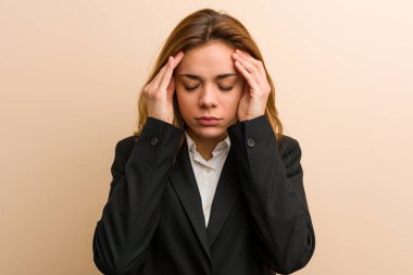 Genç beyaz iş kadını şakaklarına dokunuyor ve başı ağrıyor..