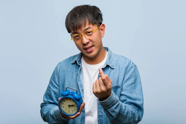 Young Chinese Man Holding Alarm Clock Inviting Come — 스톡 사진