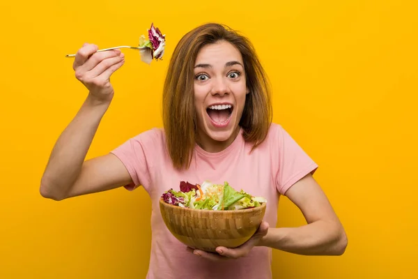 Mujer joven vegana comiendo una ensalada fresca y deliciosa . — Foto de Stock