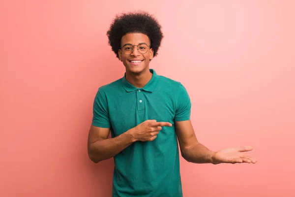 Fiatal Afroamerikai Férfi Mint Egy Rózsaszín Fal Kezében Valami Kézzel — Stock Fotó