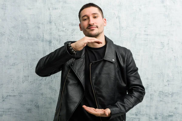 Genç rockçı iki eliyle bir şey tutuyor..