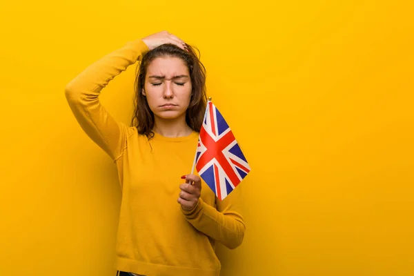 Joven Mujer Europea Sosteniendo Una Bandera Del Reino Unido Conmocionada — Foto de Stock