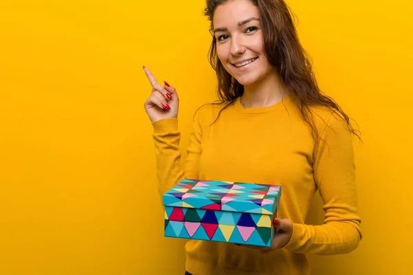 Jovem Mulher Europeia Segurando Presente Sorrindo Alegremente Apontando Com Dedo — Fotografia de Stock