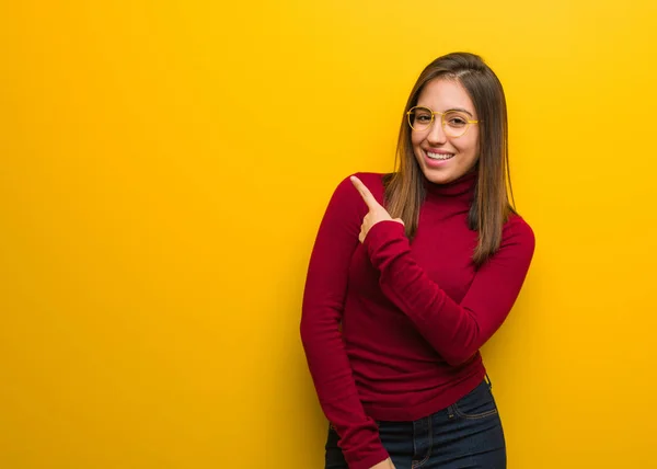 Young intellectual woman smiling and pointing to the side