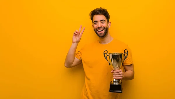 Mladý Muž Drží Trofej Dělá Vítězné Gesto — Stock fotografie