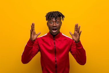 Genç fitness siyah adam hoş bir sürpriz alıyor, heyecanlı ve el kaldırıyor..