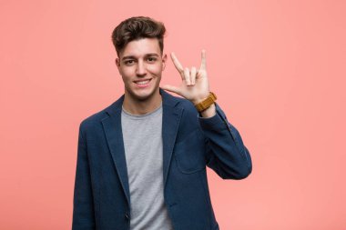 Genç iş adamı boynuzlarını bir devrim konsepti olarak gösteriyor..