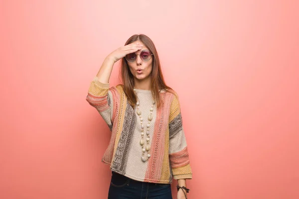 Young hippie woman on pink background tired and very sleepy