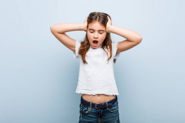 Sevimli kız sevinçle baş elleri tutarak gülüyor. Mutluluk kavramı.