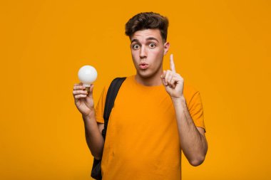 Ampul tutan genç bir öğrenci rahatlamış fotokopi odasına bakan bir şey düşünüyor..