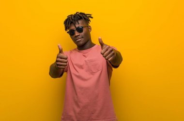 Güneş gözlüğü takan genç siyahi bir adam, bir konuda şerefe, destek ve saygı konsepti..