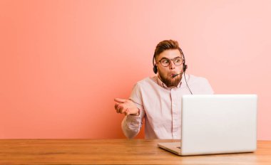 Çağrı merkezinde çalışan genç adam omuz silker ve gözleri açık kalır..