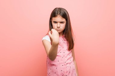 Sevimli küçük kız kameraya yumruk gösteren, agresif yüz ifadesi.