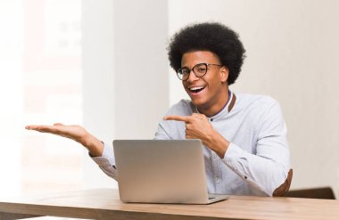 Genç siyah adam kullanarak onun laptop tutan bir şey ile el