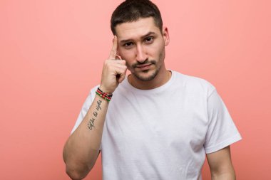 Genç, sıradan bir adam şakağı parmağıyla işaret ederek, düşünerek, bir göreve odaklanmış..