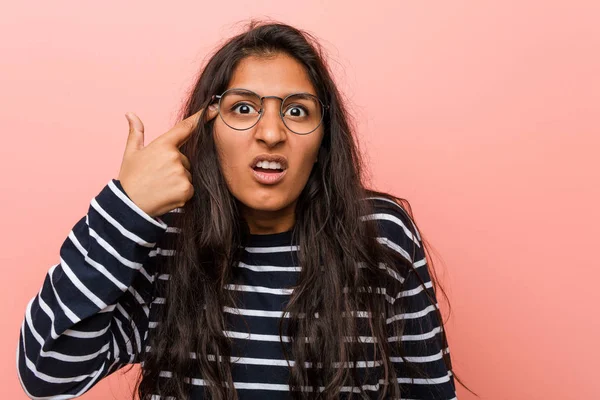 Young intellectual indian woman showing a disappointment gesture with forefinger.