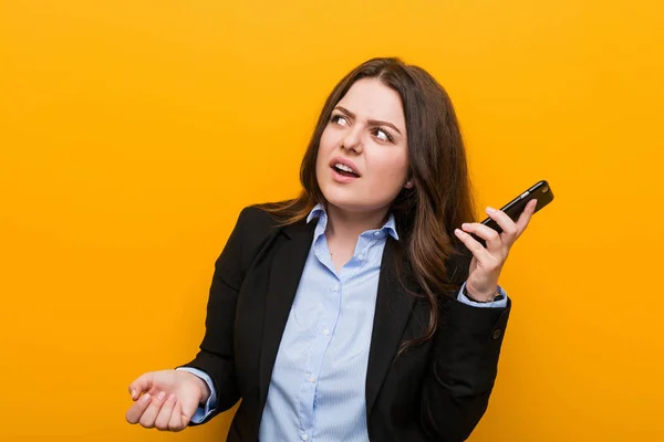 若いカービープラスサイズのビジネス女性はゴシップを聞こうとして電話を保持 — ストック写真