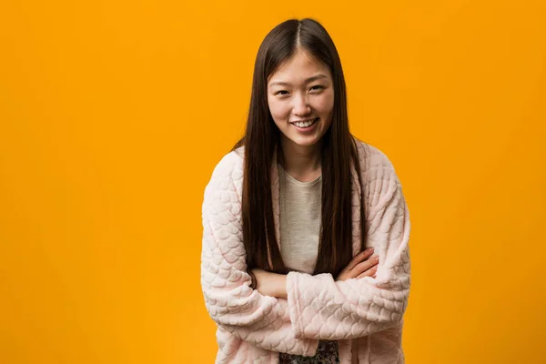 Young chinese woman in pajama laughing and having fun.